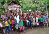 Children with their teacher in front of their classroom.